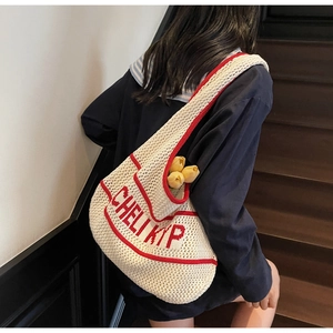 Close-up of the textured knit pattern and red lettering on the cream crochet tote bag
