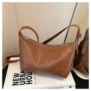Detail of caramel leather crossbody bag with vertical stitching and silver metal zipper