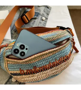 Capacity detail of straw woven crossbody bag with phone inside showing zippered pocket
