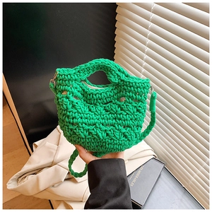 Close-up of bright green crochet knit texture and woven strap on a summer bucket bag