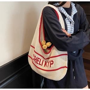 Close-up of red and white striped knit tote bag with hollow texture and letter design
