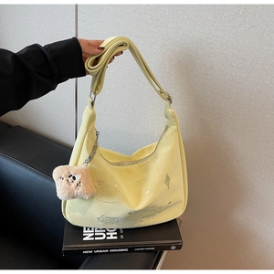 Detail of yellow hobo bag with cat embroidery on book showing texture and plush charm