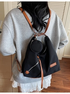 Versatile black nylon tote bag with brown leather straps and a detachable round coin purse