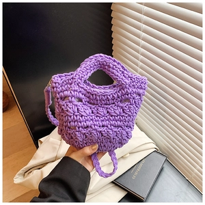 Detail of hand-held purple hand-woven bucket bag with thick knit texture and handle