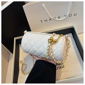Détail du sac cylindre blanc matelassé avec chaîne dorée et boule de réglage