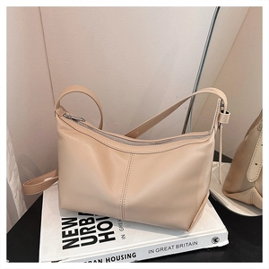 Detailed view of beige faux leather shoulder bag with decorative vertical stitching