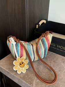 Rainbow striped woven beach bag with brown leather straps and yellow sunflower charm