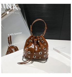 Detail of vintage brown bucket bag with industrial silver studs and metal chain strap