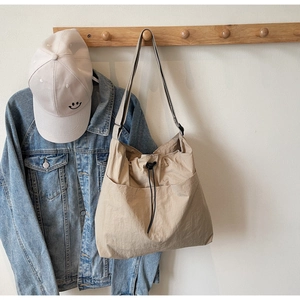 Detailed view of lightweight nylon tote bag featuring drawstring closure and front pocket