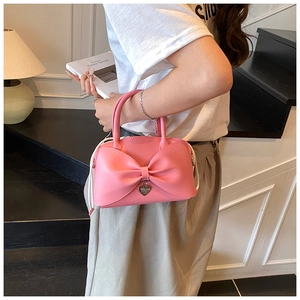 Détail du sac seau rose en cuir PU avec grand nœud et pendentif en forme de cœur