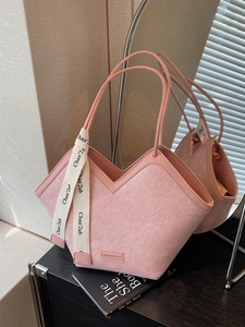 Pink pleated leather tote bag with V-cut top and contrasting lettered woven strap