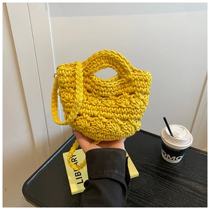 Detail of yellow hand-woven bucket bag with intricate hollow-out knitting texture