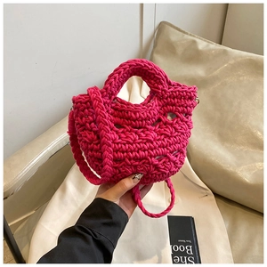 Detail of hand-woven magenta knit bucket bag texture with integrated strap for summer