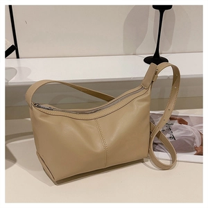 Detail of beige hobo bag showing fine leather texture and silver zipper closure