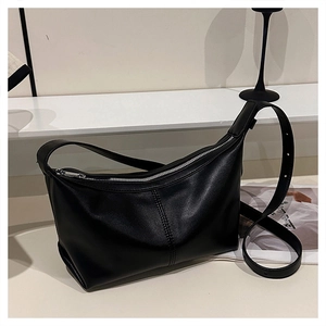 Detail of minimalist black hobo bag with high-quality vertical stitching and silver zipper