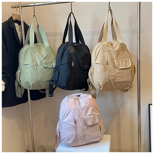 Detail showing various colors of nylon backpacks with multi-pocket functional design