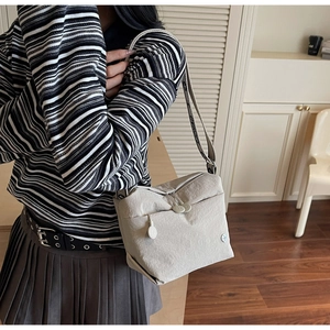 Detail of multi-compartment canvas crossbody bag with jacquard letter strap