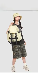 Détail d'un sac à dos en nylon beige clair avec fermeture à boucles et poches à zip noir