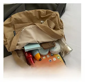 Detailed interior of khaki travel backpack showing spacious storage for a tablet and cosmetics