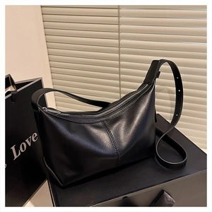 Detail showing high-quality black matte leather texture and silver zipper on hobo bag