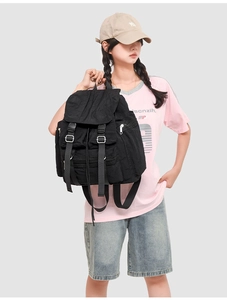 Détail d'un sac à dos noir en nylon avec sangles à boucles et poches multiples de rangement