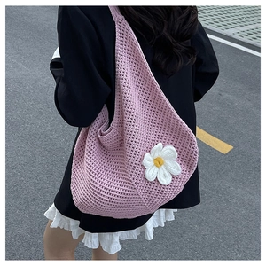 Gros plan détaillé d'un grand sac fourre-tout tissé rose avec applique florale marguerite