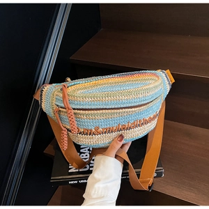Detail of colorful woven straw bag with adjustable strap and decorative tassel zip
