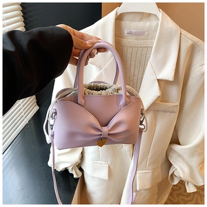 Détail du sac à main lavande avec nœud, pendentif cœur doré et sac intérieur avec cordon