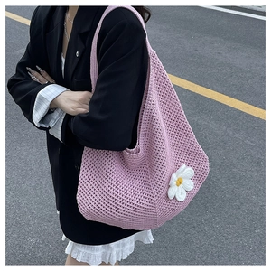 Détail du sac cabas rose tricoté avec une marguerite 3D blanche et un style urbain