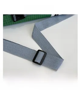 Détail de la bandoulière grise réglable et boucle sur sac en nylon à carreaux