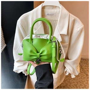 Gros plan du sac seau vert vif avec grand nœud et pendentif en forme de cœur