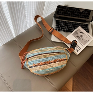 Detailed close-up of woven dumpling bag with blue stripes and brown canvas strap