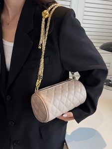 Sac cylindrique matelassé beige avec bandoulière chaîne dorée et boule en métal