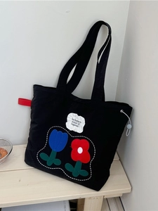 Floral canvas tote bag in black featuring colorful tulip embroidery and ruffled patch