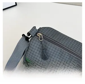 Détail macro du tissu en nylon à carreaux et de la fermeture éclair en métal argenté