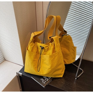 Detailed view of yellow bucket bag with drawstring closure and side pockets