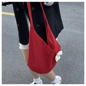 Détail du sac cabas en crochet rouge avec un accessoire de fleur de marguerite 3D