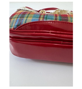 Detail of red plaid fabric and cream lace trim on a retro style vintage handbag