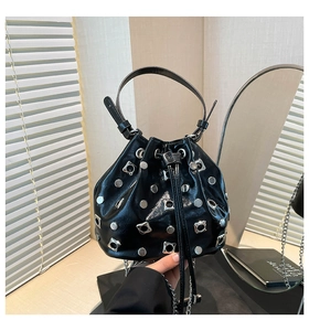 Detail of black glossy bucket bag with silver studs and metal chain strap