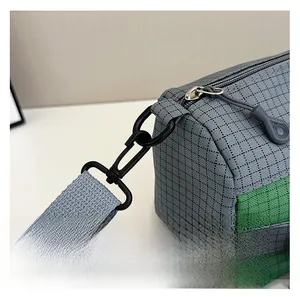 Détail des crochets métalliques amovibles et texture quadrillée sur le sac en nylon