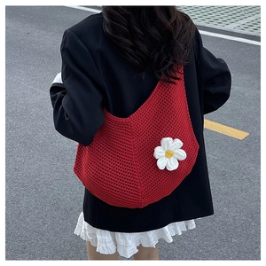 Détail du sac hobo en crochet rouge avec fleurs de marguerite 3D et maille tissée