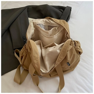 Top view showing the spacious interior compartments and zipper pocket of the khaki backpack