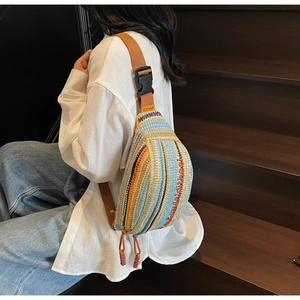 Macro detail of colorful woven texture and orange adjustable strap on the sling bag