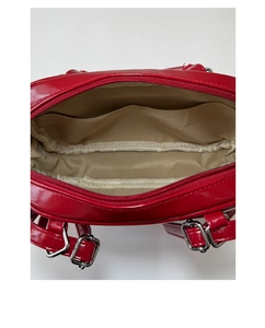 Top view of red patent leather tote interior with beige lining and silver metal buckle