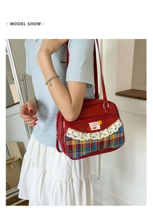 Detail of red JK style tote bag with white lace trim and plaid fabric patchwork detail
