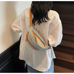 Detail showing the colorful woven stripes and adjustable strap of the cross-body bag