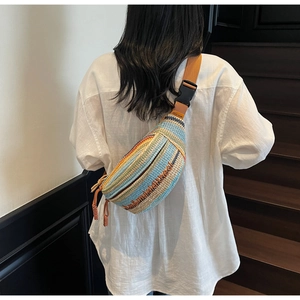 Detailed close-up of colorful striped woven crossbody bag with canvas strap and plastic buckle