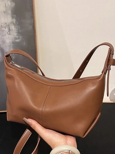 Brown vintage half-moon leather shoulder bag with decorative stitching and silver zipper
