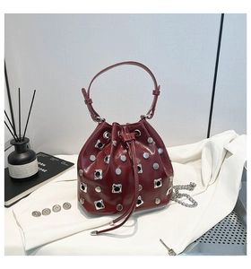 Detail of wine red bucket bag with silver studs and polished leather finish