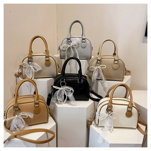 Detail view of lychee pattern Boston bags in six colors with lace bow charms